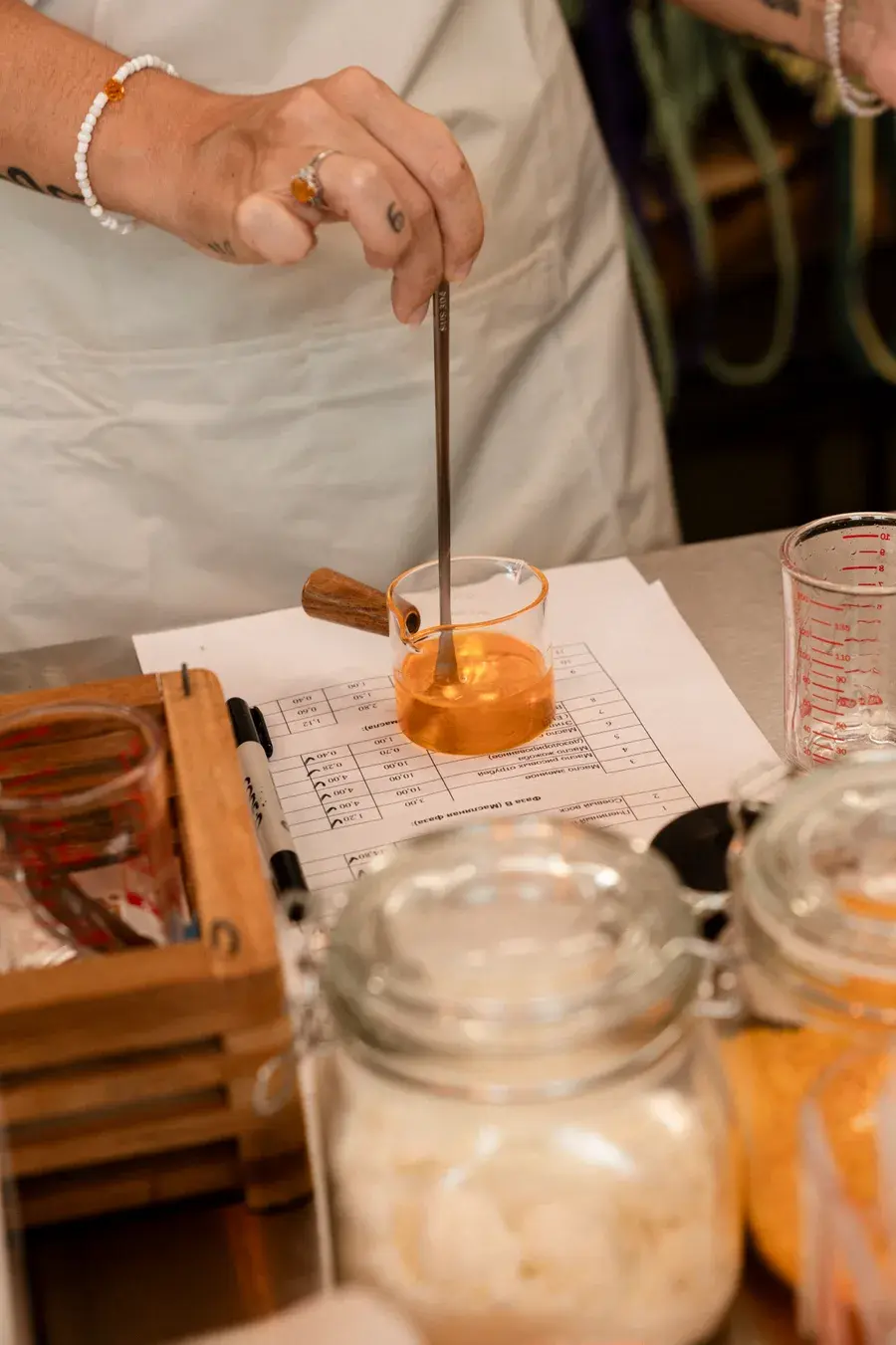 Natural balm workshop Phuket — participant stirring beeswax and botanical oils